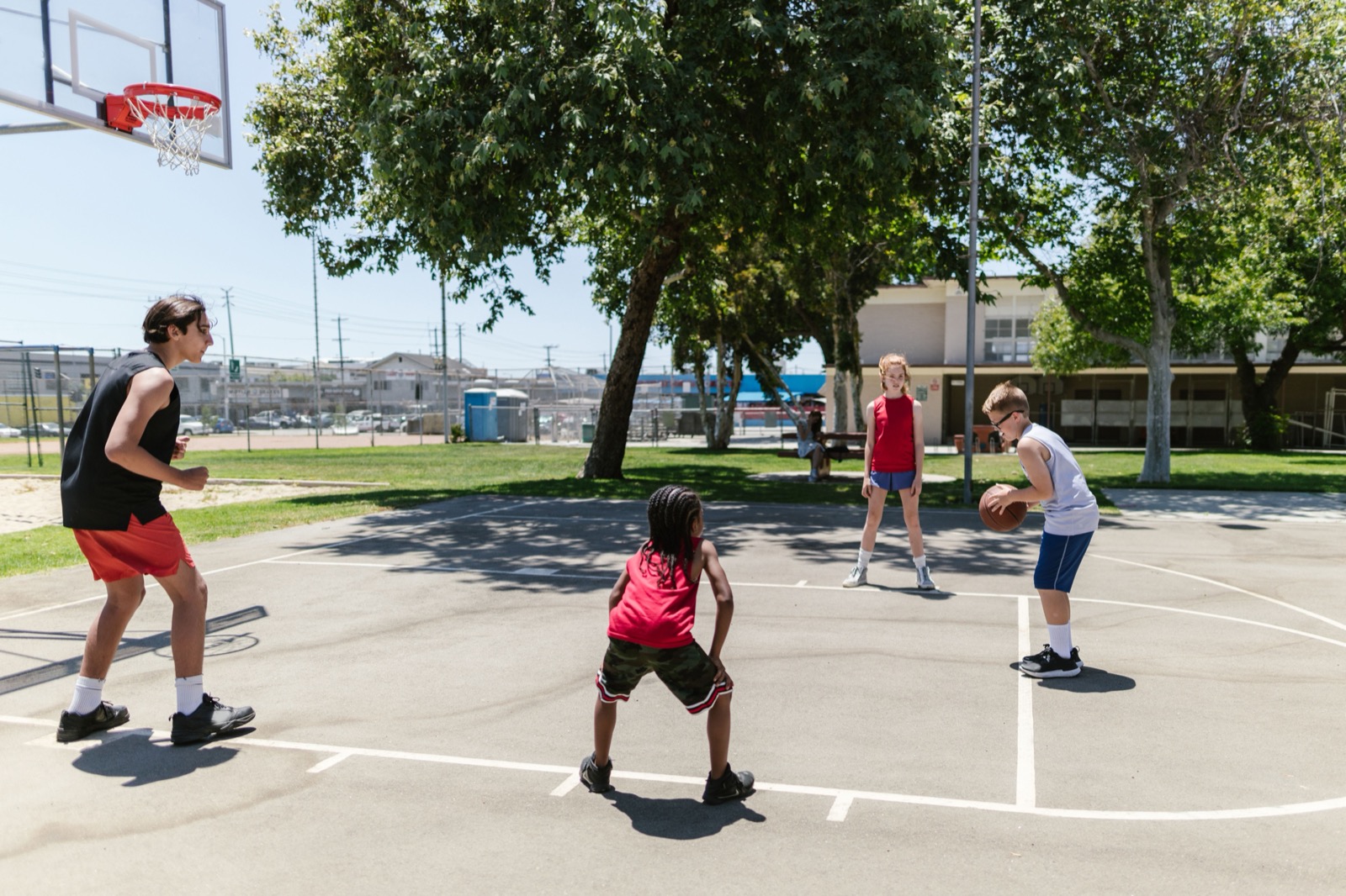 Young people playing basketball together on an outdoor court