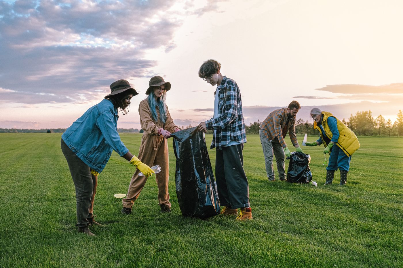 Volunteers working together to collect litter from a grassy field