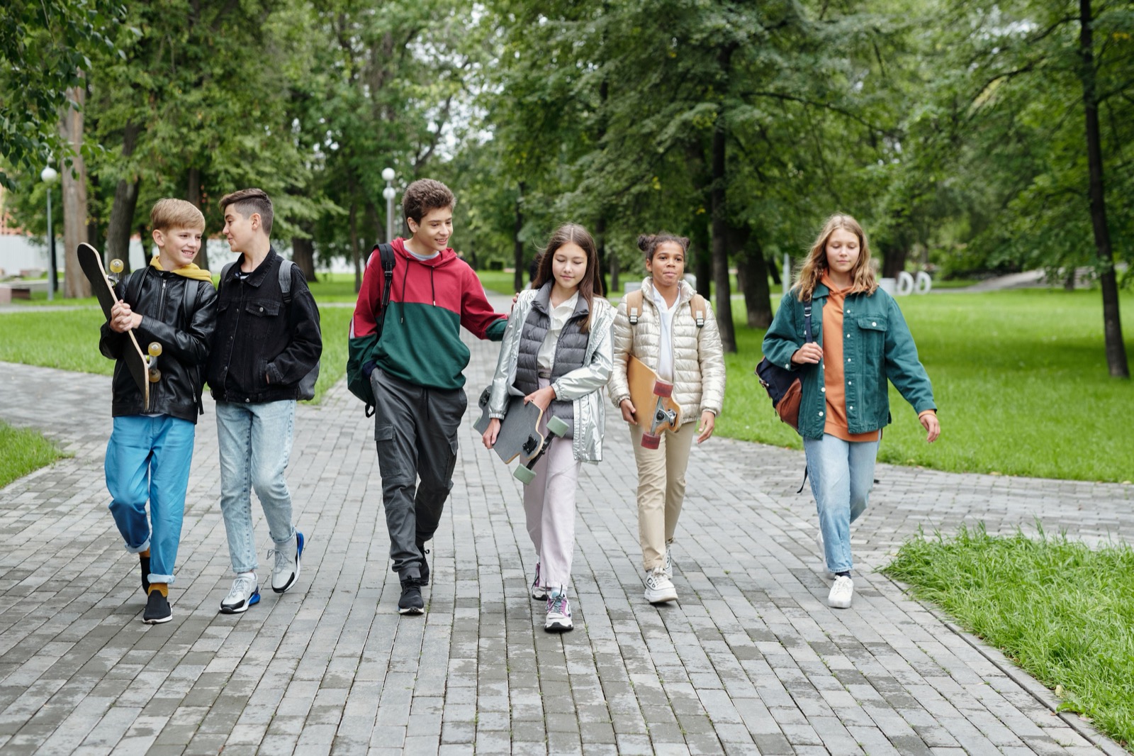 Young friends walking and talking together in a park